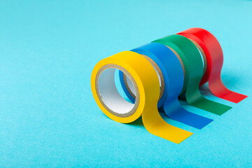 Insulating tape on a bright colored background. Set of different colors insulating tape. Reel...