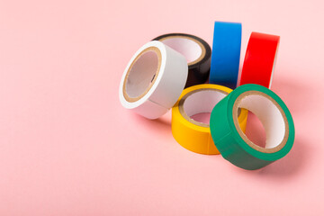 Insulating tape on a bright colored background. Set of different colors insulating tape. Reel...