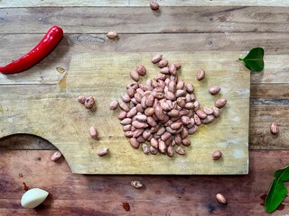 Peeled Organic Raw Peanuts on a wooden cutting board on a wooden table, healthy snack, preparation...