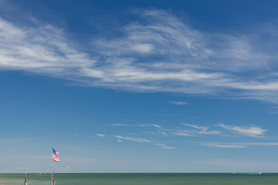 American Flag with Clouds and Ocean