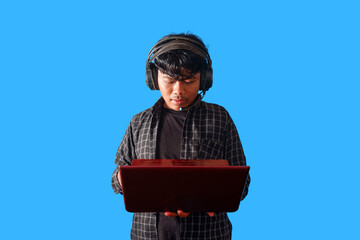 Focused Young Man Working on Laptop with Headphones  isolated on blue background