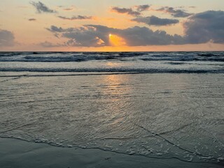 Sunrise at a tropical beach with soft golden tones reflecting on the calm sea. Peaceful and...