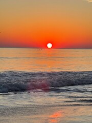 Sunrise at a tropical beach with soft golden tones reflecting on the calm sea. Peaceful and...