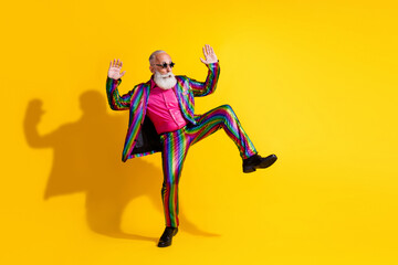 Full size photo of extravagant funny man dancing empty space wear shiny costume isolated on yellow...