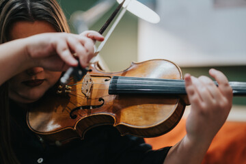 A detailed shot of a young musician performing on a violin, highlighting musical dedication.