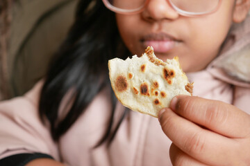  little girl enjoying traditional flatbread during meal