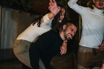 Friends having a joyful and playful time together during an evening gathering outdoors.