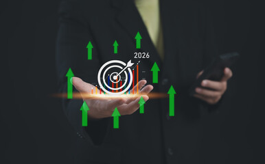Hand holding a glowing target icon with growth chart and upward green arrows, representing business...