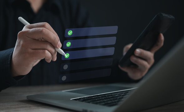 User completing checklist tasks using stylus and mobile device over a digital interface, representing task management, synchronization, productivity, and workflow tracking in modern work systems.