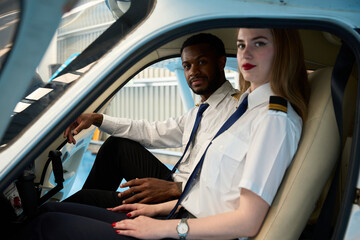 Student pilots training in cockpit of small airplane