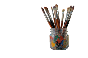 Artist's palette sits on a table with colorful paint splatters while brushes stand upright in a jar, creating a vibrant workspace by a window with blurred urban background