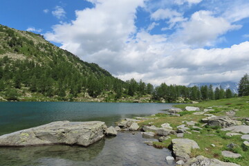 L'incantevole lago di Arpy in Valle d'Aosta, circondato dal verde e dalle montagne.
