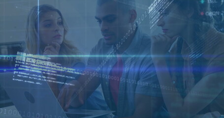 Collaborating tech team pointing and typing on laptop at office desk, with binary code overlay