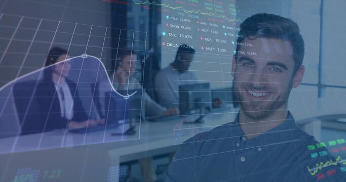 Smiling man wearing blue shirt using laptop at desk in office, with digital stock chart overlays