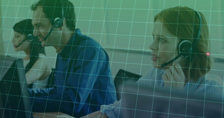 Working three call center agents taking calls at office desk with headsets, monitors, keyboards