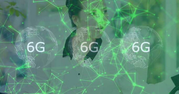 Asian woman wearing white shirt using laptop at office desk, 6G overlay with 3 globe icons