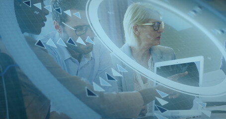 Reviewing professionals in suits examining laptop screen at conference table with data graphics