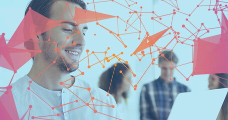Smiling man wearing gray shirt presenting network visualization on laptop at office, copy space