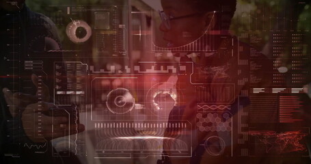 Reviewing woman wearing headset, glasses and blazer leaning in at office desk, with data overlays