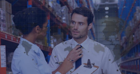 In warehouse, workers discussing logistics with animated world map overlay