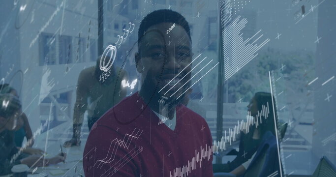 Smiling man in office with financial data processing image overlay