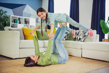 Mother and daughter enjoying playful bonding moments together at home on a cozy weekend indoors