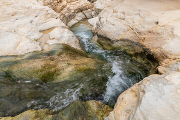 Shallow  mountain river flows along the winding channel in Arugot Stream Nature Reserve near Dead Sea in southern Israel