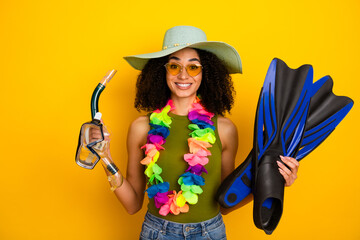 Young woman with summer accessories posing against a vibrant yellow backdrop showcasing stylish...
