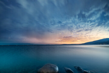 Beautiful night landscape, long exposure clouds over the lake. Starry night. 