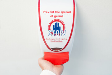 Hospital medic seen using a typical antibacterial foam had dispenser within an NHS hospital. Used before entry to a surgical ward.