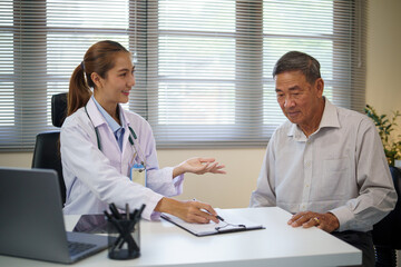 Female doctor having a discussion with an elderly patient during a medical consultation. Health...