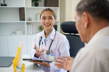 Doctor and patient discussing orthopedic treatment options with the aid of an anatomical model.
