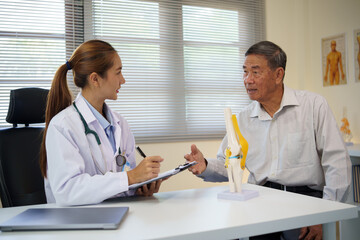 Elderly man consulting with a physician about joint pain and mobility issues in a clinical. Health...