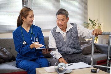 Female nurse showing health records to elderly man at home during routine checkup. Health care...