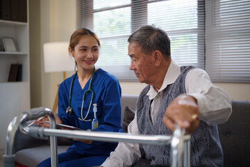 Female nurse showing health records to elderly man at home during routine checkup. Health care...