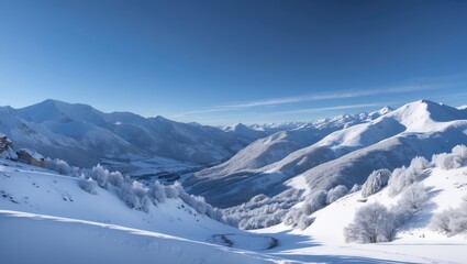 Obraz premium Snow-covered mountain landscape with peaks and trees under a clear blue sky.