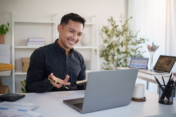 Happy businessman having an online discussion during a virtual meeting in a modern office.