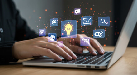 Creative Technology at Work: A person, focused on a laptop, is surrounded by digital icons representing technological innovation and communication, a dynamic display of creativity and progress.