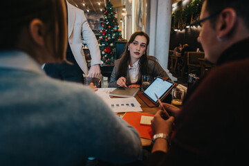 A group of professionals brainstorming and discussing a project during a meeting at a cozy cafe...
