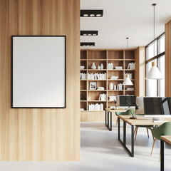 A minimalist office interior boasts clean lines, wood accents, and modern workspaces, with a prominent blank frame for display