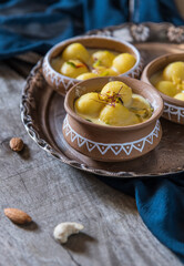 Traditional Ras Malai Served in Clay Bowls on a Rustic Wooden Table