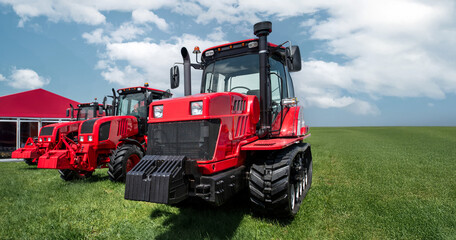 Two red tractors are parked in a field