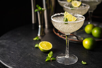 Margarita cocktail with lime and ice on dark wooden table with copy space. Classic Margarita and Daiquiri Cocktail.