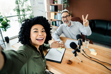 Friendly coworkers recording a podcast in a stylish office showcasing collaboration and teamwork