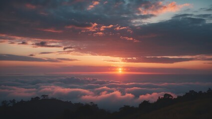 Fototapeta premium A sunset over clouds with a colorful sky and silhouetted trees below.