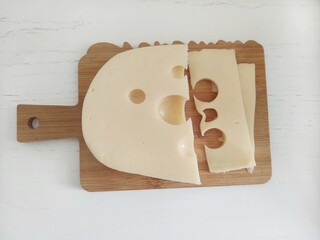 Sliced Swiss Cheese on Wooden Cutting Board Close-Up