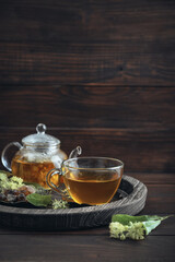 Glass cup of linden tea with glass teapot