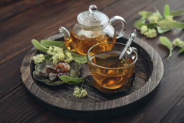 Glass cup of linden tea with glass teapot