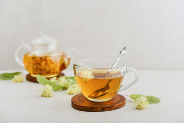 Glass cup of linden tea with glass teapot