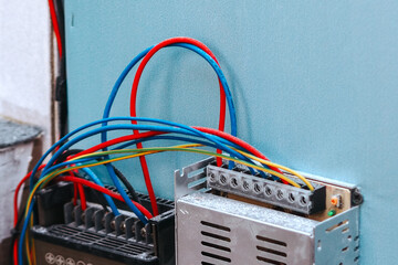 close-up of an electrical setup, likely involving a power supply unit and a terminal block, mounted...